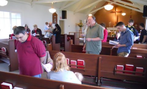 The congregation reciting their baptismal vows.